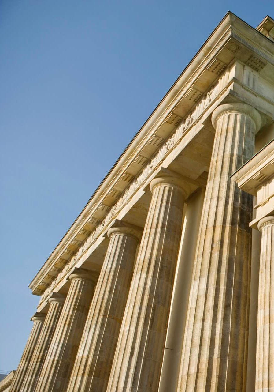 Stone columns of a classical building against a blue sky