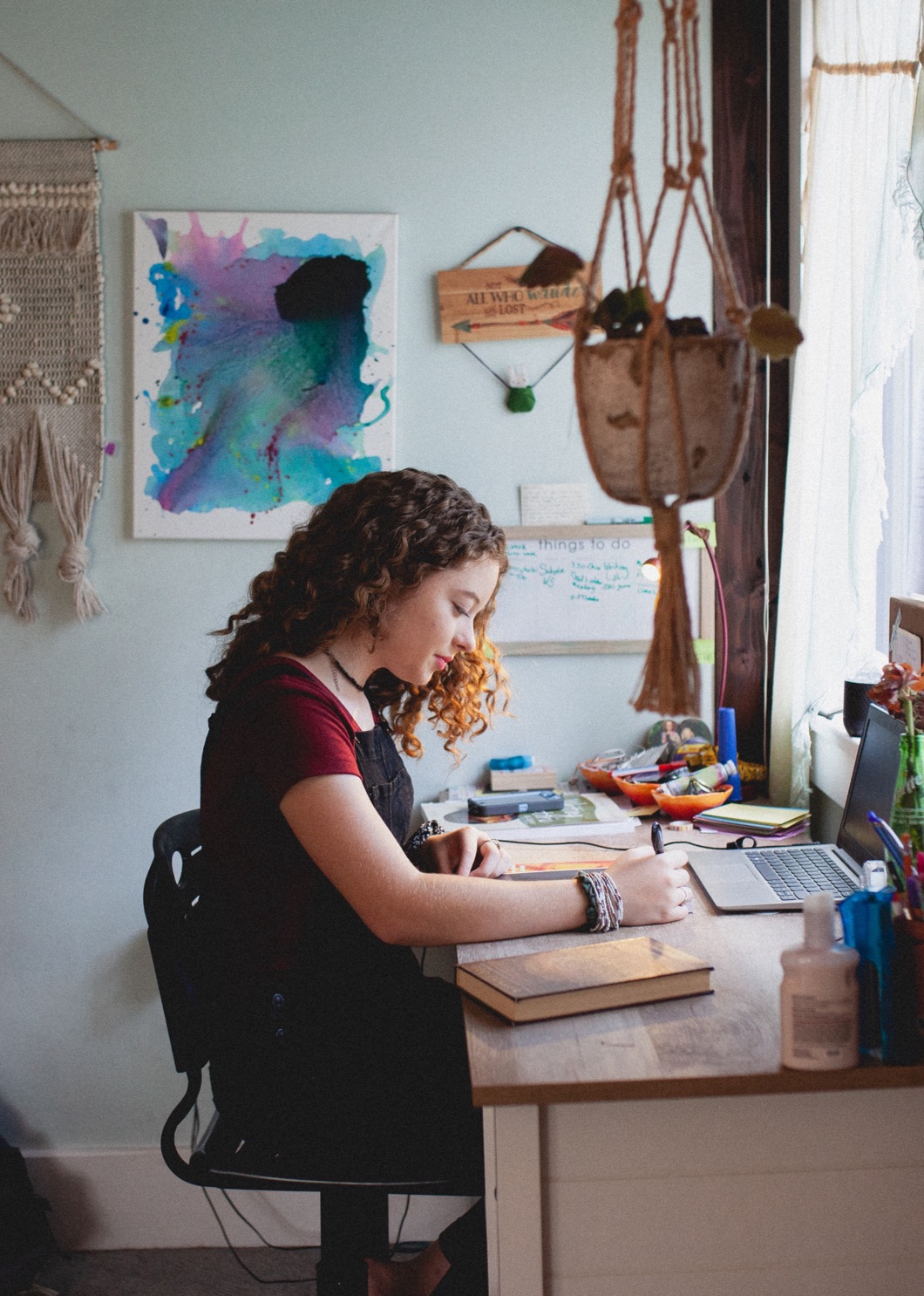 A student working at a desk by a window during an online class