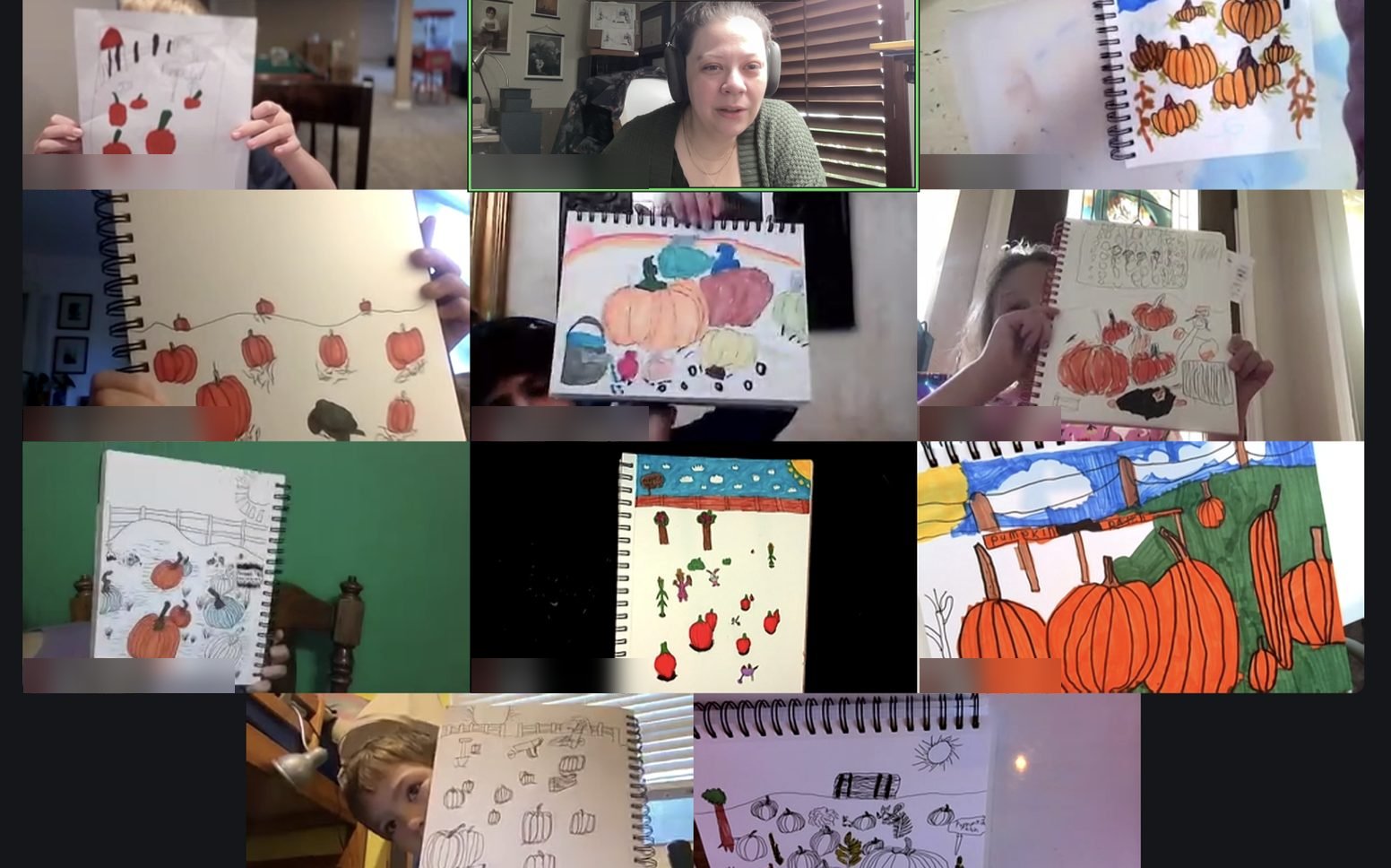 A live video class with students holding up their drawings