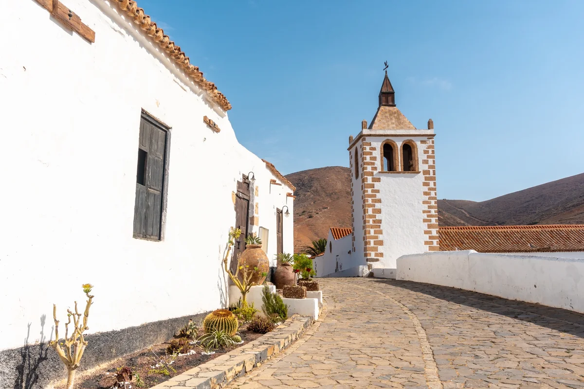 Whitewashed village church on a cobbled street in Spain, the culture a classical Spanish curriculum opens up
