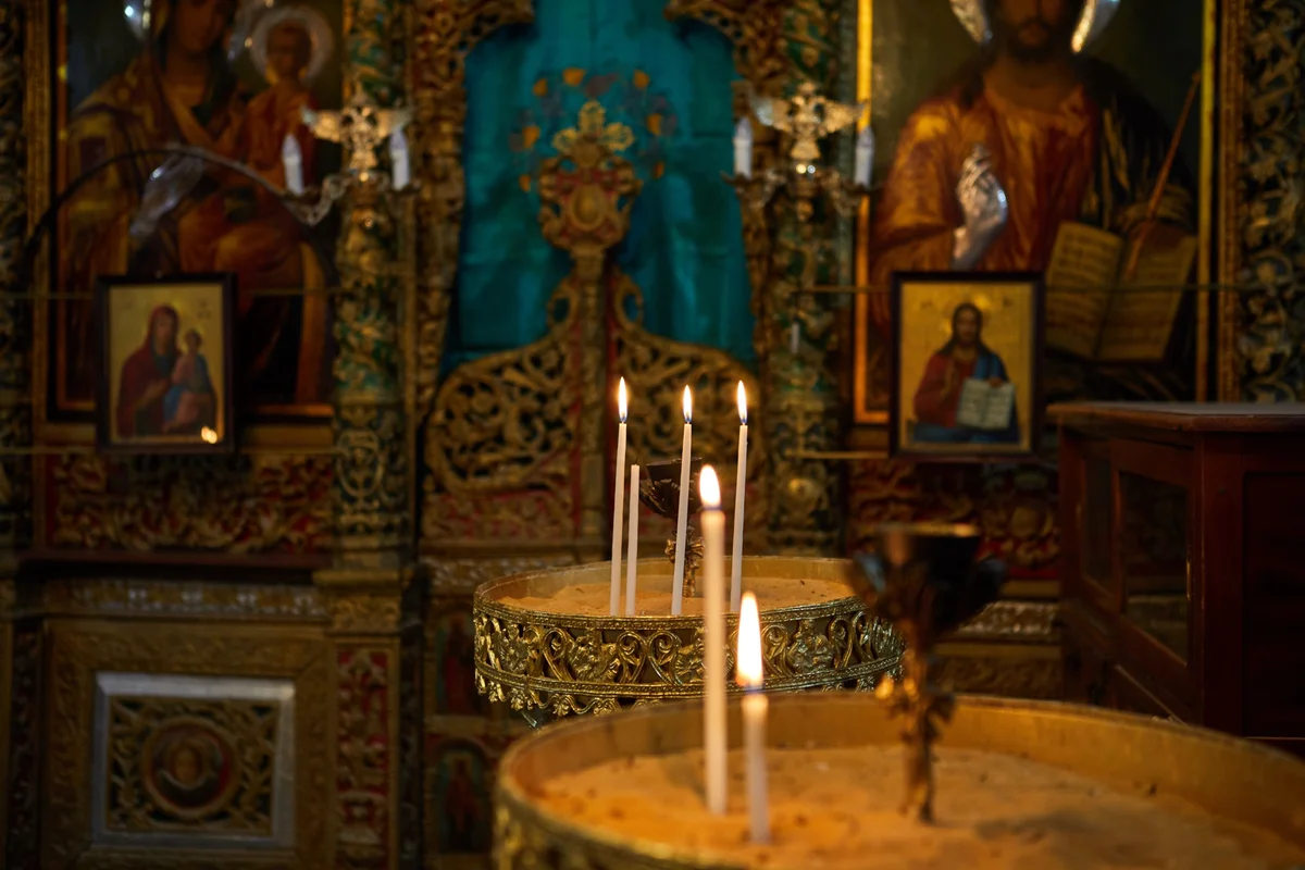 Thin beeswax candles burning before gilded icons, the light of the Pascha festival, the Feast of Feasts
