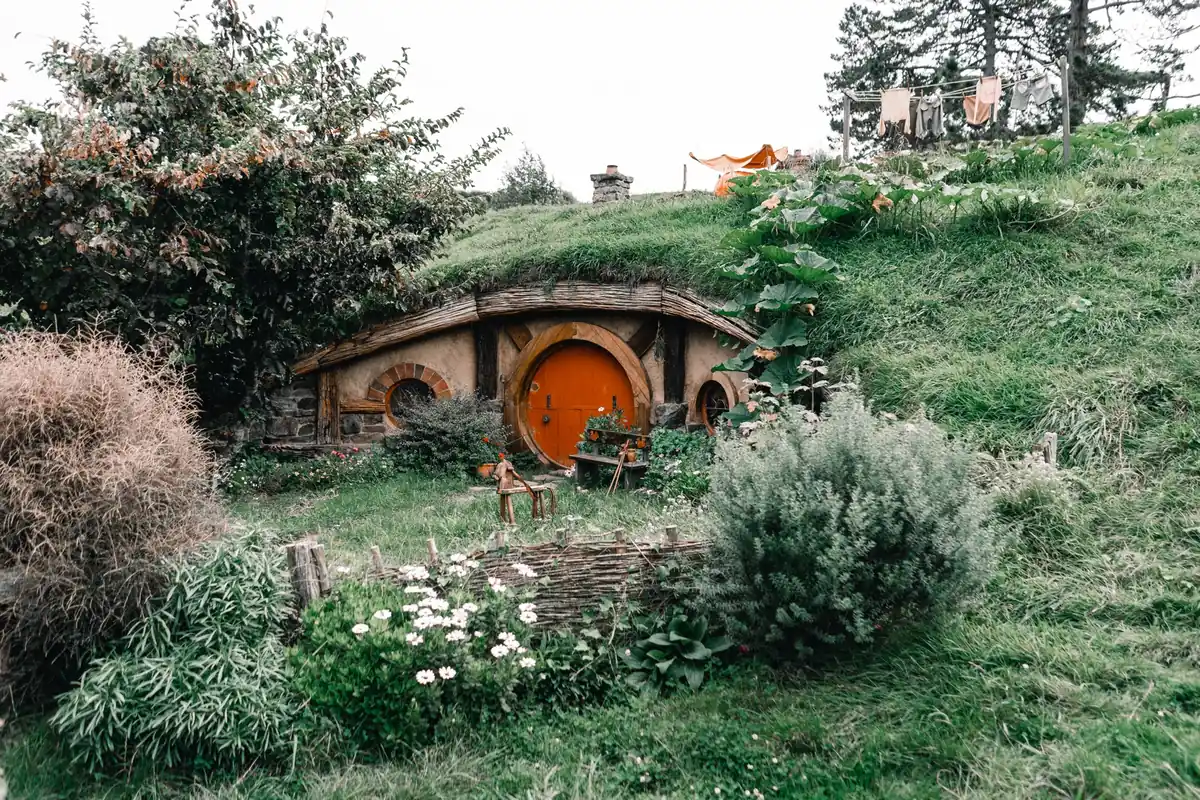 Round orange door set into a grassy hillside like a hobbit hole, a reminder of fortitude in The Hobbit