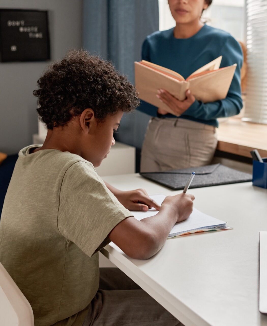 A young student reading a book at a desk
